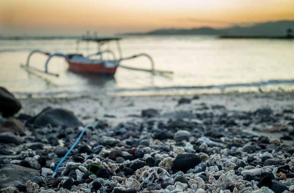 Coral on beach in Candidasa, Bali, Indonesia with boat in background | Travel Photography
