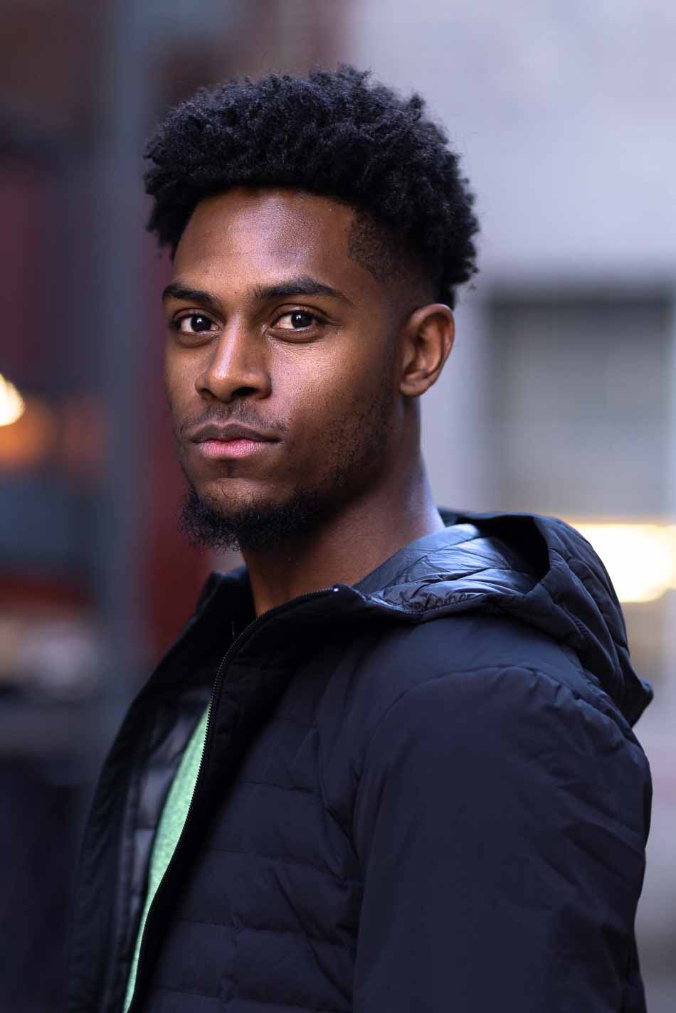 Attractive black man looks directly at the camera.